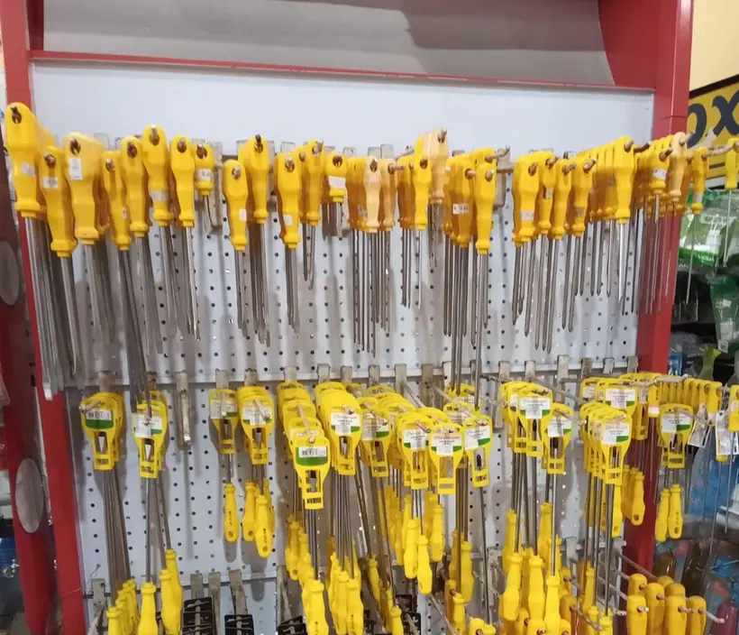 Ferramentas de cabo amarelo penduradas no expositor do Lojão da Construção